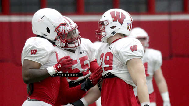 Wisconsin inside linebackers Jordan Turner (54), Maema Njongmeta (55), and Tate Grass (39) talk during spring practice. (Credit: Mike De Sisti / Milwaukee Journal Sentinel / USA TODAY NETWORK)